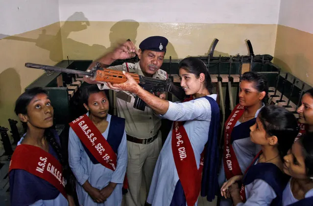 A police officer shows the functions of a gun to schoolgirls during their visit inside a police station as part of the 50th Raising Day celebrations of Chandigarh Police in Chandigarh, India, November 2, 2016. (Photo by Ajay Verma/Reuters)