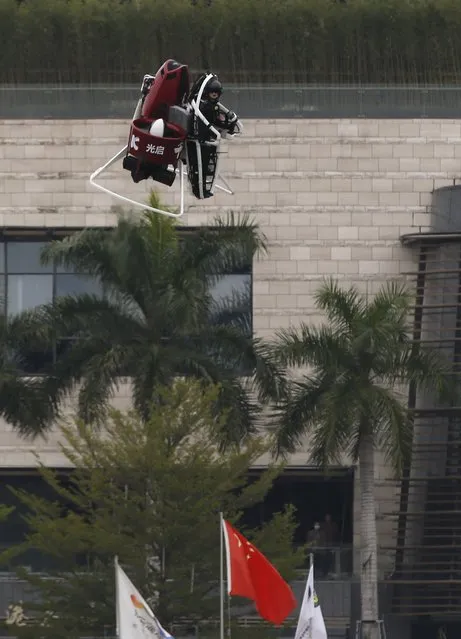 Michael Read, Director of Flight Operations from New Zealand-based Martin Aircraft Company, flies past a Chinese flag on a Martin Jetpack during a demonstration at a water park in Shenzhen, China December 6, 2015. (Photo by Bobby Yip/Reuters)