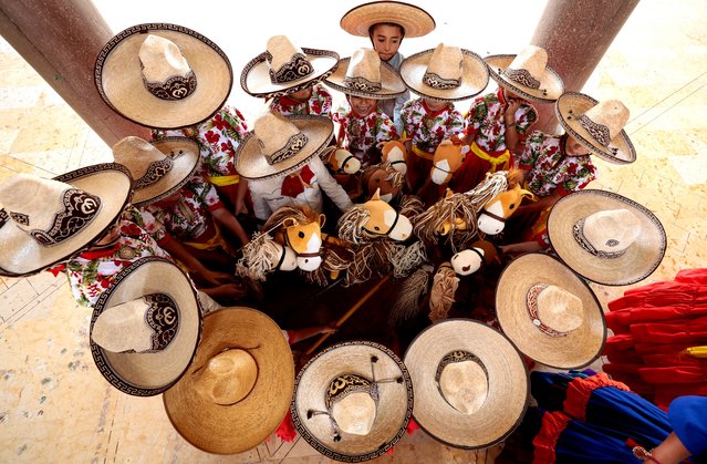Students dressed as a “Escaramuza Charra” (woman on horseback) attend a class with their wooden stick horses at the “Caballito de Palo” Charreria Sports Academy in Ameca, Jalisco state, Mexico, on September 7, 2024. Charreria Sports Academy “Caballito de Palo” offers classes for girls aged 3-8 using a wooden hobby horse, promoting Mexican traditions during September Mexico's Independence celebrations. The traditional charreria is a sport arising from equestrian activities and livestock traditions and has been a part of Mexican culture since colonial times. It was declared the Intangible Cultural Heritage of Humanity by UNESCO in 2016. (Photo by Ulises Ruiz/AFP Photo)