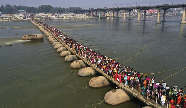 Indian Hindu devotees gather to take holy dips at Sangam, the confluence of the rivers Ganges and the Yamuna on 'Mauni Amavasya' or new moon day, an auspicious bathing day during the annual month long Hindu religious fair “Magh Mela” In Prayagraj, India. Thursday, February 11, 2021. Hundreds of thousands of Hindu pilgrims take dips in the confluence, hoping to wash away sins during the month-long festival. (Photo by Rajesh Kumar Singh/AP Photo)