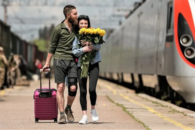 A couple meets at the railway station in Kramatorsk, Donetsk region, Ukraine, 28 May 2023. Under martial law, Ukrainian servicemen are entitled to 10 days of vacation per year. Some of their family members travel to areas closer to the frontline to make the most out of the short time they have available to spend with servicemen, while they’re on a rotational leave. Russian troops entered Ukraine in February 2022, starting a conflict that has provoked destruction and a humanitarian crisis. (Photo by Oleg Petrasyuk/EPA/EFE)