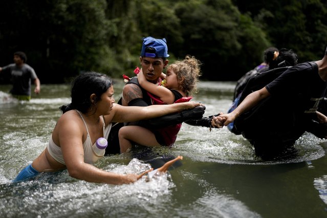 Venezuelan migrant Alvaro Calderini carries his niece across a river near Bajo Chiquito, Panama, after walking across the Darien Gap from Colombia on their way north to the United States, Saturday, November 9, 2024. (Photo by Matias Delacroix/AP Photo)