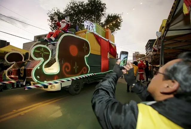 A man takes pictures with a mobile phone during a Christmas parade in La Paz, Bolivia, December 12, 2015. (Photo by David Mercado/Reuters)