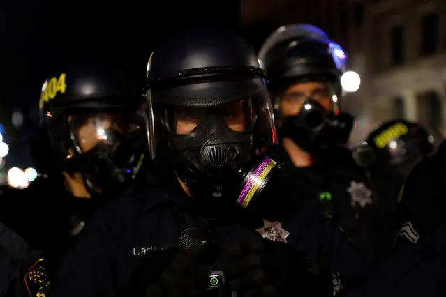 Members of the Oakland Police Department in gas masks form a line on Broadway during a demonstration following the election of Donald Trump as President of the United States, in Oakland, California, U.S. November 10, 2016. (Photo by Stephen Lam/Reuters)