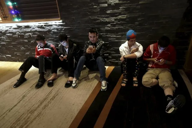 Refugees use smartphones in the lobby of their camp at a hotel touted as the world's most northerly ski resort in Riksgransen, Sweden, December 15, 2015. (Photo by Ints Kalnins/Reuters)