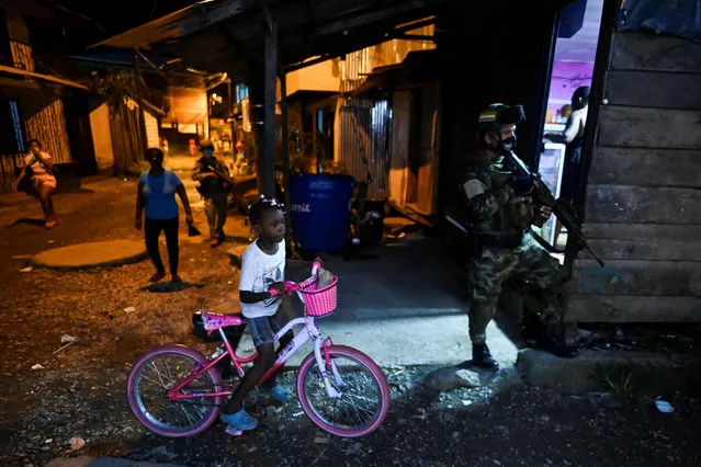 Colombian Marine Infantry soldiers patrol the streets of Buenaventura, Colombia, on February 10, 2021. Since December, 2020, Buenaventura has been suffering a blood and fire dispute between members of the La Local armed group, which split into two substructures known as Shotas and Espartanos, that are now facing each other to death for the control of drug trafficking. (Photo by LLuis Robayo/AFP Photo)