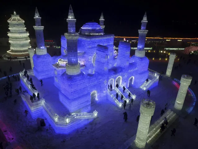 Visitors tour the Ice and Snow World in Harbin in northeastern China's Heilongjiang province on Tuesday December 22, 2015, the night of the soft opening of the annual tourist attraction. (Photo by Chinatopix via AP Photo)