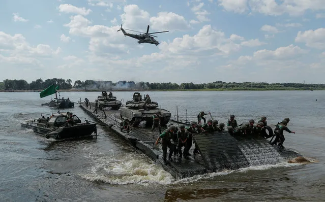 Members of the Russian team transport tanks on a pontoon bridge during the Open Water competition for pontoon bridge units, as part of the International Army Games 2018, outside Murom, Russia, August 3, 2018. (Photo by Maxim Shemetov/Reuters)