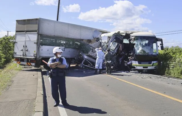 A police stands at the scene of a crash between a bus and a truck in Yakumo, Hokkaido prefecture, northern Japan on June 18, 2023. Several people were killed and 12 others taken to the hospital after a truck collided with a bus in Hokkaido in northern Japan, according to local media reports.(Photo by Kyodo News via AP Photo)