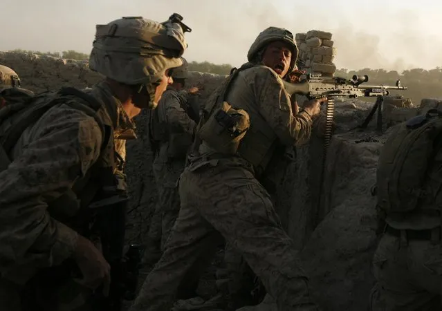 U.S. Marines fire during a Taliban ambush as they carry out an operation to clear an area in Helmand province, October 9, 2009. (Photo by Asmaa Waguih/Reuters)