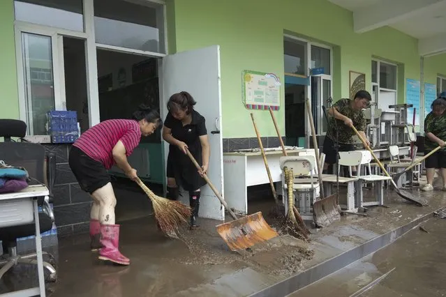 In this photo released by Xinhua News Agency, teachers clean classrooms at a school in the aftermath of flood waters from an overflowing river in Qizhongkou Town of Laishui County in north China's Hebei Province on August 11, 2023. A vast swath of northeastern China is threatened by flooding as at least 90 rivers have risen above warning levels and 24 have already overflowed their banks. State media say crews are standing by to defend homes and farmland across the Songliao Basin north of Beijing which includes parts of four provinces and several major cities with a total population of almost 100 million. (Photo by Wang Kun/Xinhua via AP Photo)