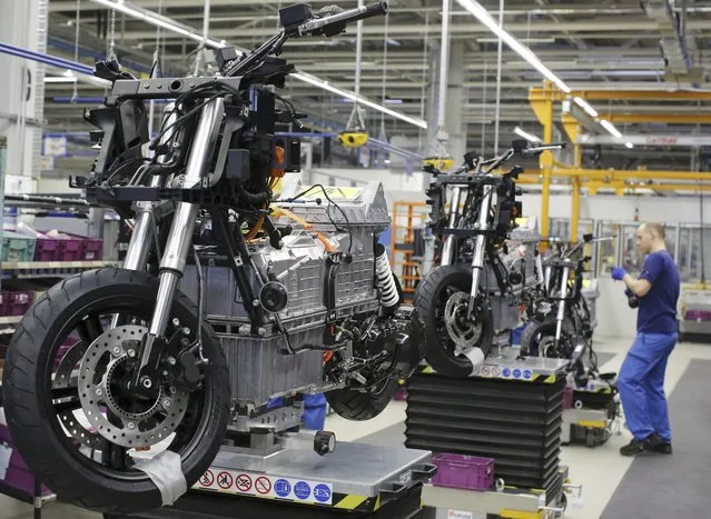 A mechanic assembles a BMW C evolution electric maxi-scooter at the BMW Berlin motorcycle plant February 23, 2015. The storage capacity of the BMW C evolution's high-voltage 8 kWh battery provides a range of up to 100 kilometres and a maximum speed of 120 km/h. (Photo by Fabrizio Bensch/Reuters)