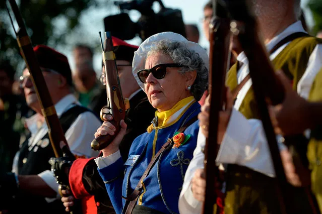 A woman holds a blunderbuss gun in Sant Julia de Ramis, near Girona, on October 1, 2018 during a ceremony to commemorate the anniversary of a banned referendum on secession that was marred by police violence. On October 1, 2017, Catalan separatists held an illegal and divisive referendum which saw them launching a failed attempt to break away from Spain. A year on, however, the independence movement is divided and rudderless. (Photo by Josep Lago/AFP Photo)