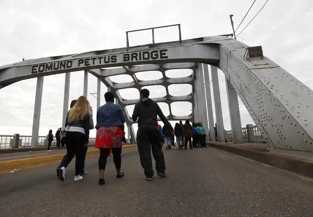 People walk along the Edmund Pettus Bridge before the beginning of the 50th anniversary of the Selma to Montgomery civil rights march in Selma, Alabama March 8, 2015. REUTERS/Tami Chappell  (UNITED STATES - Tags: POLITICS ANNIVERSARY SOCIETY)