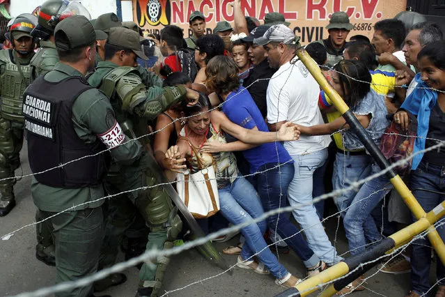 People clash with Venezuelan National Guards as they try to cross the border to Colombia over the Francisco de Paula Santander international bridge in Urena, Venezuela December 18, 2016. (Photo by Carlos Eduardo Ramirez/Reuters)