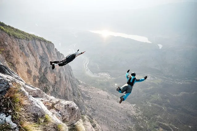 Italy's base-jumper Maurizio Di Palma (L) and Lituania's base-jumper Evelina Overlingaite jump from the Becco dell'Aquila, the exit point on the top of Monte Brento near Trento, Northern Italy, on June 4, 2021. Mount Brento, near Lake Garda in northern Italy is one of the most known BASE jumping cliff across the world with his 1000 meter high wall almost completely overhanging in the first 400 meters and a large landing area. (Photo by Marco Bertorello/AFP Photo)