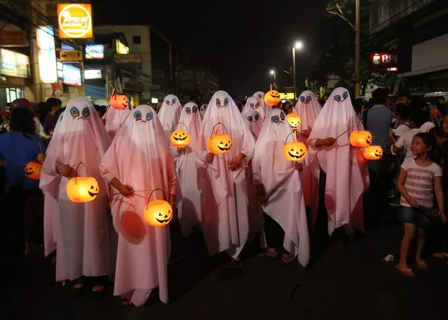 Filipinos wear ghost costumes as they join a Halloween Parade in Marikina city, east of Manila, Philippines on Wednesday, October 30, 2013. Hundreds of residents and government employees joined the parade as the country prepares to observe All Saints Day on November 1. (Photo by Aaron Favila/AP Photo)