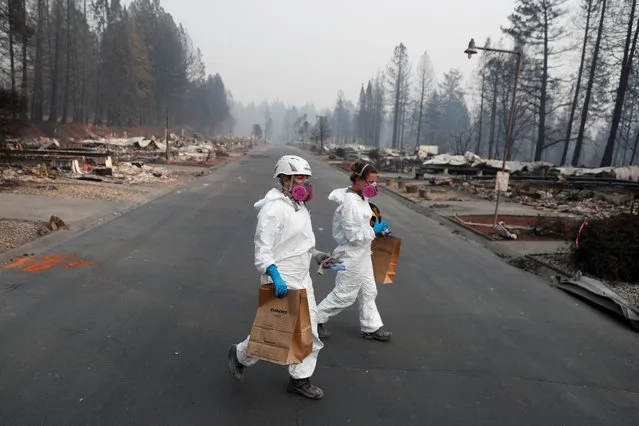 Forensic anthropologists Kyra Stull (C) and Tatiana Vlemincq (R) recover human remains from a trailer home destroyed by the Camp Fire in Paradise, California on November 18, 2018. (Photo by Terray Sylvester/Reuters)