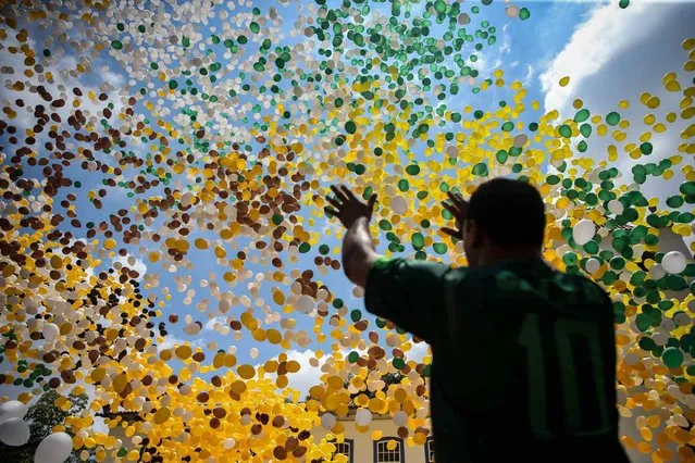 A member a Sao Paulo's trade association gestures as some 50,000 biodegradable balloons are released at the Patio do Colegio square in sao Paulo, SP, Brazil, 30 December 2016. The tradition of releasing balloons weas steablished in 1992 to celebrate the New Year. (Photo by Fernando Bizerra Jr./EPA)
