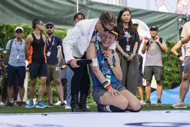 Participants react at the AIDS Quilt Memorial Ceremony, ahead of the Gay Games in Hong Kong, Saturday, November 4, 2023. The first Gay Games in Asia are fostering hopes for wider LGBTQ+ inclusion in the regional financial hub, following recent court wins in favor of equality for same-s*x couples and transgender people. (Photo by Chan Long Hei/AP Photo)