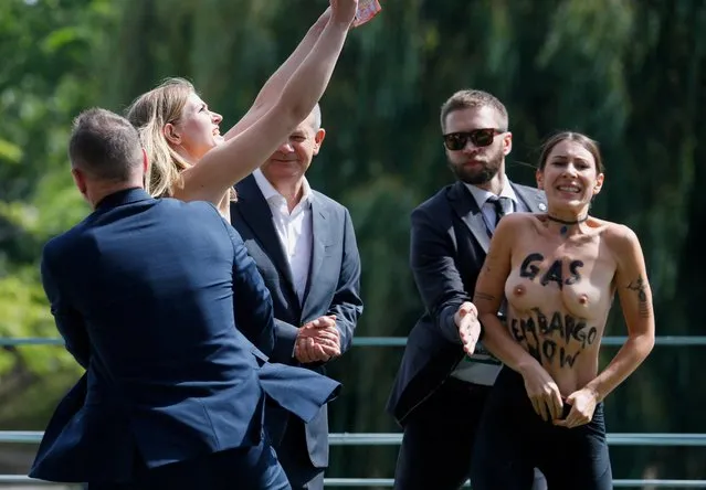 Security takes away a protester trying to approach German Chancellor Olaf Scholz on the grounds of the chancellery during the government's “Open House Day” in Berlin, Germany on August 21, 2022. (Photo by Michele Tantussi/Reuters)