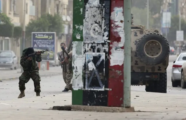 A member of the Libyan army shoots towards members of Islamist militant group Ansar al-Sharia during clashes between the group and a Libyan army special forces unit in the Ras Obeida area in Benghazi November 25, 2013. (Photo by Esam Omran Al-Fetori/Reuters)