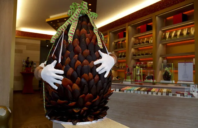 British pastry cook Michael Lewis-Anderson holds a sixty-kilogram giant chocolate egg with candied orange peel in the form of an artichoke at a Wittamer chocolate boutique ahead of the Easter weekend in Brussels April 3, 2015. (Photo by Francois Lenoir/Reuters)