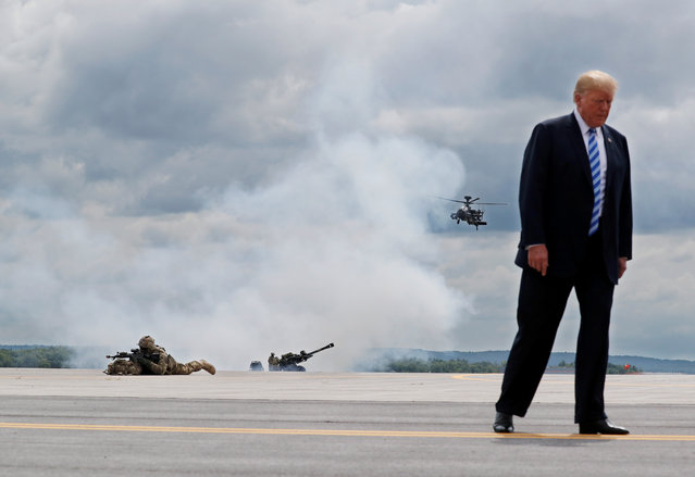 U.S. President Donald Trump observes a demonstration featuring U.S. Army 10th Mountain Division troops, an attack helicopter and artillery during a visit to Fort Drum, New York, August 13, 2018. (Photo by Carlos Barria/Reuters)