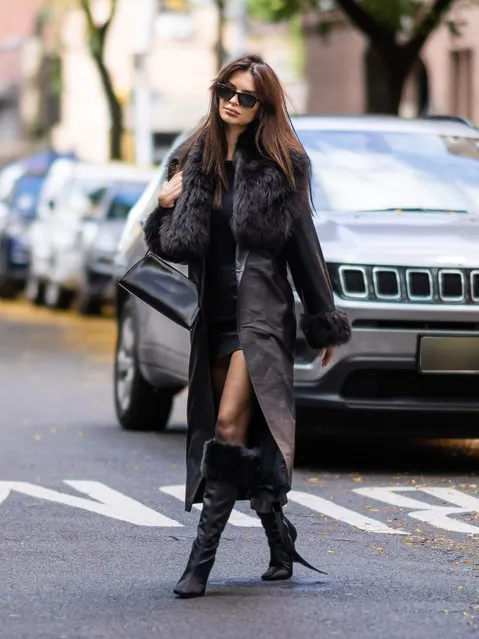 Emily Ratajkowski looks fashionable stepping out in New York City on October 31, 2023. The American supermodel wore a faux fur trimmed trench coat, black blouse, matching leather mini skirt, and knee high boots. (Photo by The Image Direct)