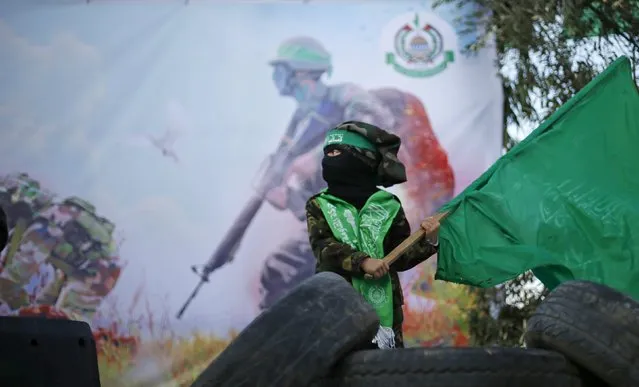 A masked Palestinian boy wearing a military fatigue waves a Hamas flag during a rally in support of what organizers said is a Palestinian uprising against Israel, in Beit Lahiya town in the northern Gaza Strip January 22, 2016. (Photo by Suhaib Salem/Reuters)