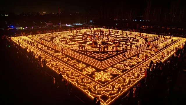 Aerial view of butter lamps lit on the square in front of the Puning Temple, also known as the Big Buddha Temple, at night to celebrate Butter Lamp Festival on December 7, 2023 in Chengde, Hebei Province of China. (Photo by Sun Zhanjun/VCG via Getty Images)