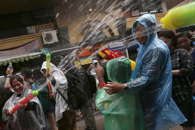 Revellers take part in a water fight during Songkran Festival celebrations at Kowloon City district, known as Little Thailand as there is large number of restaurants and shops run by Thais, in Hong Kong April 12, 2015. (Photo by Tyrone Siu/Reuters)