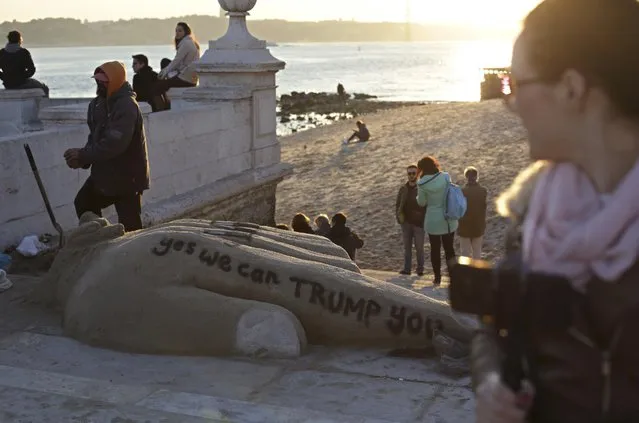 A man builds a sand sculpture, with the words “yes we can TRUMP you” written on it, by the Tagus river in Lisbon Friday, January 20 2017. (Photo by Armando Franca/AP Photo)