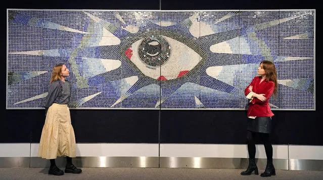 Members of staff looks at John Lennon's psychedelic eye mosaic, commissioned for the swimming pool at his home in Kenwood, Surrey, which is on display at Bonhams auction house in Kinghtsbridge, London on Monday November 27, 2023, ahead of the Rock, Pop and Film sale on Wednesday. Consisting of approximately 17,000 tiles, the mosaic was created by Joseph Ritrovato, a master tiler who single-handedly installed it on the deep-end wall of John Lennon's swimming pool at Kenwood in Surrey, which he owned from July 1964 to late spring 1968. (Photo by Jonathan Brady/PA Wire)
