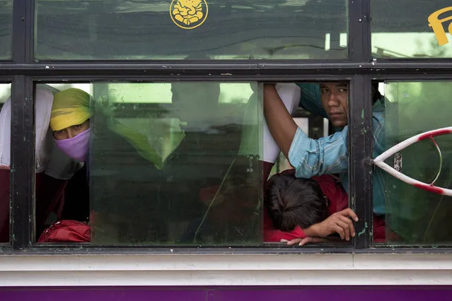 Nepalese people look out from inside a bus where they have taken shelter as it is considered safer in cars than inside houses with repeated aftershocks, in Kalanki neighbourhood of Kathmandu, Nepal, Sunday, April 26, 2015. (Photo by Bernat Armangue/AP Photo)