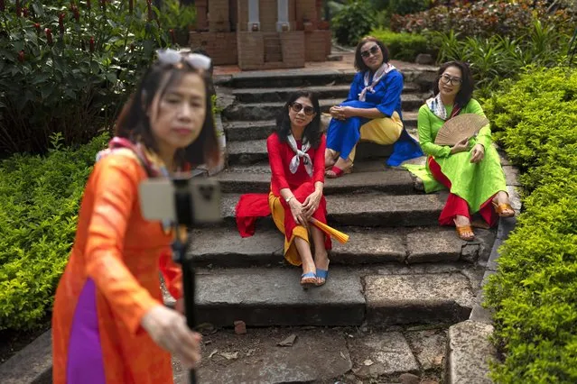 Anh Nguyen, foreground, sets up her phone to take a group photo with her friends at a park in Ho Chi Minh City, Vietnam, January 14, 2024. (Photo by Jae C. Hong/AP Photo)
