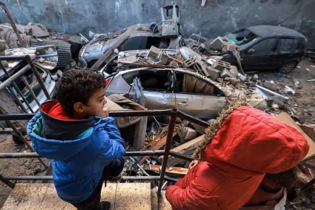 Children look on as they stand by rubble, debris, and a destroyed vehicle in the aftermath of Israeli bombardment on Rafah in the southern Gaza Strip on February 7, 2024, amid the ongoing conflict between Israel and the Palestinian militant group Hamas. (Photo by Mohammed Abed/AFP Photo)