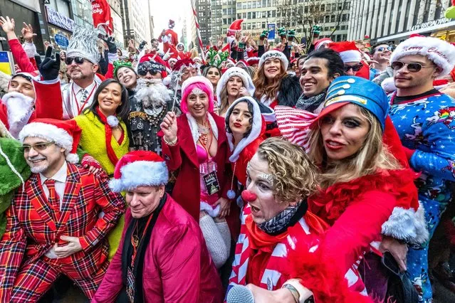 Revelers dressed as Santa Claus have fun near Times Square during the annual SantaCon in New York City on December 10, 2022. (Photo by Enrique Shore/Alamy Live News)