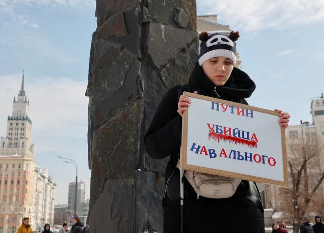A woman holds a placard reading “Putin is the killer of Navalny” during a gathering in memory of Russian opposition leader Alexei Navalny near the Wall of Grief monument to the victims of political repressions in Moscow, Russia on February 17, 2024. (Photo by Reuters/Stringer)