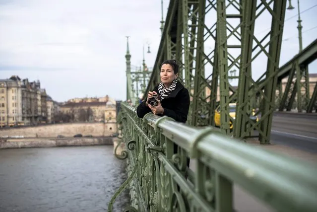 Camerawoman Eszter Csepeli makes a record of the capital with an old Super 8 camcorder on Liberty Bridge in Budapest, Hungary, 05 March 2016. (Photo by Bea Kallos/EPA)