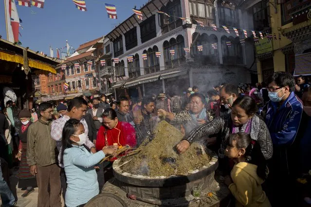 Nepalese Buddhists light incense sticks at the Boudhanath Stupa during Buddha Jayanti, or Buddha Purnima, festival in Kathmandu, Nepal, Monday, May 4, 2015. Hundreds of people have visited Buddhists shrines and monasteries in Nepal’s quake-wracked Kathmandu on Buddha Purnima to pray for the country and the people who suffered during April 25 earthquake. (Photo by Bernat Amangue/AP Photo)