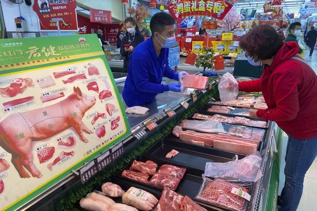 An employee attends to a customer at a supermarket in Beijing, China, Wednesday, November 3, 2021.  A recent seemingly innocuous government recommendation for Chinese people to store necessities for an emergency quickly sparked scattered instances of panic-buying and online speculation of imminent war with Taiwan. (Photo by Ng Han Guan/AP Photo)