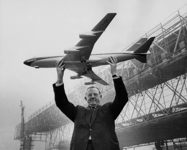 Keith Granville, Managing Director of BOAC, holding up a model of the Boeing 747 jet, with the new aircraft hangars under construction in the background, Heathrow Airport, London, March 17th 1969. (Photo by Jim Gray/Keystone/Getty Images)