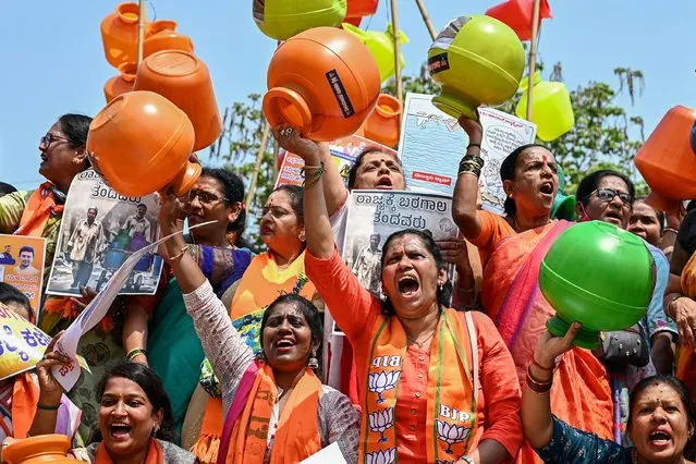 Activists and members of the Bharatiya Janata Party (BJP) hold empty water pots as they shout slogans during a protest against the state government over ongoing severe water crisis, in Bengaluru on March 12, 2024. (Photo by Idrees Mohammed/AFP Photo)