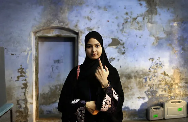 An Indian Muslim woman displays indelible ink mark on her finger after her casting at a polling station, Bengali Tola Inter college in Varanasi, India, Sunday, May 19, 2019. Indians are voting in the seventh and final phase of national elections, wrapping up a 6-week-long long, grueling campaign season with Prime Minister Narendra Modi's Hindu nationalist party seeking reelection for another five years. Counting of votes is scheduled for May 23. (Photo by Rajesh Kumar Singh/AP Photo)