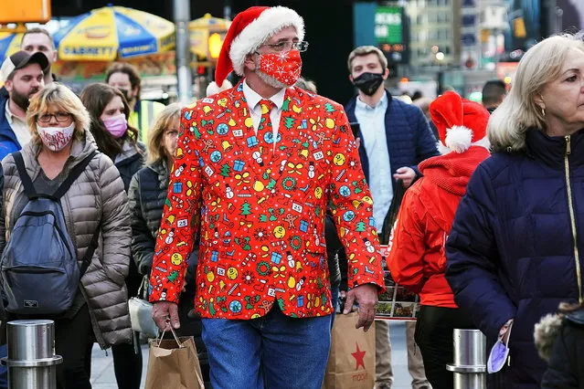 A man wearing a festive attire and a mask walks through Times Square during the coronavirus disease (COVID-19) pandemic in the Manhattan borough of New York City, New York, U.S., December 17, 2021. (Photo by Carlo Allegri/Reuters)