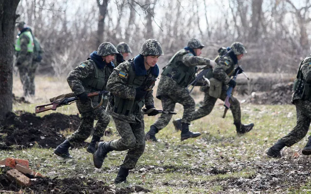 Ukrainian border guards run during exercises not far from the Alexeevka check point on the border between Ukraine and Russia, some 120 km from the eastern Ukrainian city of Donetsk on March 21, 2014. Ukraine's interim premier Arseniy Yatsenyuk on Friday called for global economic pressure against Russia to halt its drive to forge “a new world order”. (Photo by Alexander Khudoteply/AFP Photo)