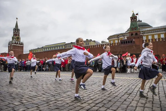 Young Pioneers march on Red Square during a ceremony to celebrate joining the Pioneers organization, in Moscow, Russia, Sunday, May 17, 2015. Pro-Communist Russians try to preserve the Young Pioneers, which used to be the Communist league for pre-teens in the Soviet Union. (Photo by Alexander Zemlianichenko Jr./AP Photo)