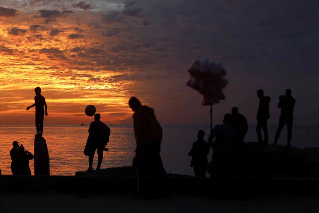 Palestinians enjoy during the sunset on the beach, in Gaza City, Saturday, December 4 , 2021. The beach is one of the few open public spaces in this densely populated city. (Photo by Hatem Moussa/AP Photo)