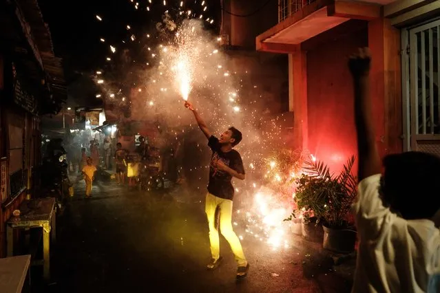 A Muslim youth sets off fireworks on the eve of Eid al-Fitr, which marks the end of the Islamic holy fasting month of Ramadan, in Jakarta on April 9, 2024. (Photo by Yasuyoshi Chiba/AFP Photo)